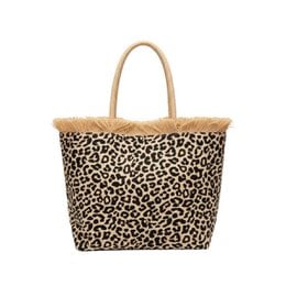 Leopard print tote bag with beige handles and trim. Made of durable material, suitable for everyday use or travel. Measures approximately 15 inches wide and 12 inches tall.