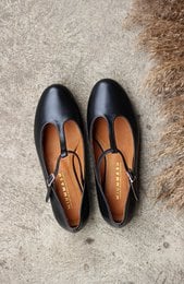 Black leather ballerina flats with a rounded toe shape, suitable for women's casual or formal wear.
