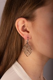 Criss-cross drop earrings with a woven metal design in a silver tone.
