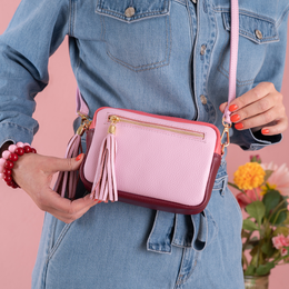  Blush pink shoulder bag with tassel detail, compact rectangular shape, crossbody style.