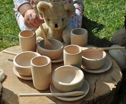 Wooden tea set with 16 pieces, including cups, saucers, and a teddy bear. Suitable for educational play or pretend tea parties.