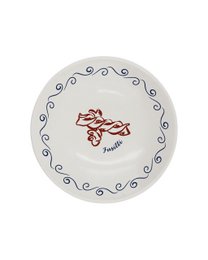 A round, white dinner plate with a green scalloped edge and a green illustration of a person in a relaxed, vacation-inspired pose.