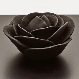 Black decorative box with rose-shaped lid, made of dark materials, suitable for storing small items or as a decorative accent piece.