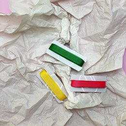 Colorful ribbon set for wrapping gifts and packages. Includes green, yellow, and red ribbons in various shapes and sizes.