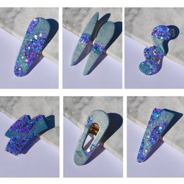 Resin hair clips in a vibrant purple glow with colorful glitter accents, perfect for adding a touch of whimsy to kids' hairstyles.