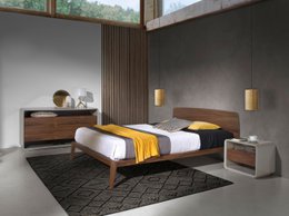 Walnut bed with modern design, featuring a low profile frame, wooden nightstands, and pendant lighting.