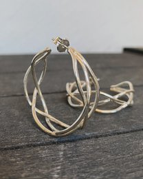 Silver tangle hoop earrings, made of metal, with a circular shape and intricate, intertwined design.