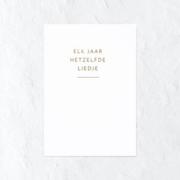 A simple, elegant birthday card with the text "Elk jaar hetzelfde liefde" (Every year the same love) in gold lettering on a white background. The card is accompanied by a pink flower, adding a touch of natural beauty to the scene.