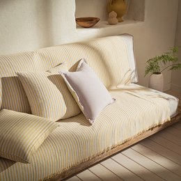 A large, cozy throw blanket in a soft, striped yellow and white pattern. The throw is made of a comfortable, lined material and comes in several size options to fit different spaces.