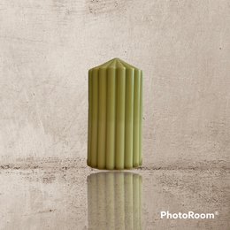 Tall, cylindrical pillar candle in a vibrant olive green color with a ribbed texture.