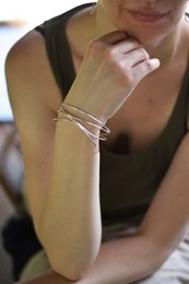 Silver double wave bangle bracelet with a sleek, modern design.