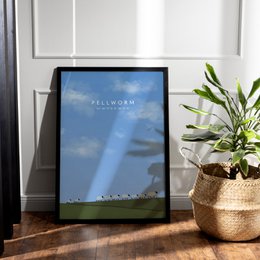  Poster featuring sheep on a dike against a blue sky with clouds. The poster has the text "Pellworm" printed on it.
