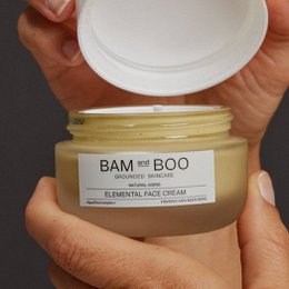 Elemental face cream in a white jar with the brand name "Bam + Boo" printed on the label. The cream appears to be a light, creamy texture.