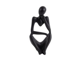  A black abstract statue of a seated figure, with a minimalist and modern design.