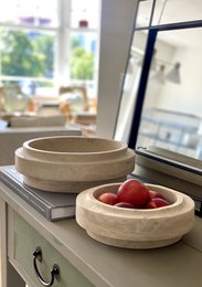 Small round travertine bowl, made of natural stone material, suitable for serving or decorative purposes.