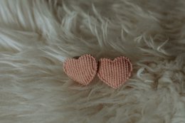 Two heart-shaped hair ties in a dusty pink color, made of a soft, textured material.