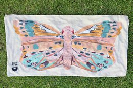  Colorful butterfly-patterned beach towel with vibrant shades of pink, blue, and orange.