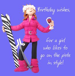 A pink puffer jacket with a fur-trimmed hood, worn by a woman holding a birthday card. The card has the text "Birthday wishes, for a girl who likes to go on the piste in style!"