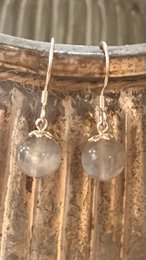 Silver stud earrings with round clear gemstones.