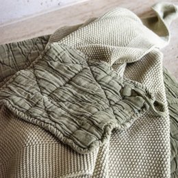 Olive-colored pacifier blanket made of soft, textured fabric with a quilted design.