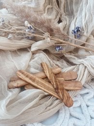 Natural cream spatula made of olive wood for skin care tools. Wooden utensil with blue accents.