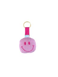 Pink fuzzy smiley face keychain with happy expression and metal ring attachment.