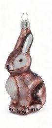 A glass ornament depicting a sitting bunny in shades of pink and white. The ornament has a textured, realistic appearance.