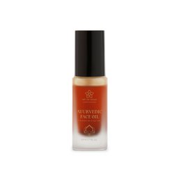  Ayurvedic face oil in a glass bottle with a black cap. The bottle is surrounded by a colorful box with floral designs.