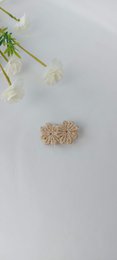 A bronze-colored hair clip in the shape of a daisy, suitable for children. The clip has a simple, minimalist design and appears to be made of a metal or metallic material.
