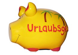 Yellow ceramic piggy bank with "Urlaubsgeld" text, vacation savings, red accents, small pig figurine.