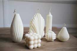 Tall, round, white pillar candle with a textured, ribbed surface.