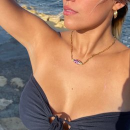 Elegant gold-tone charm necklace with purple gemstone accents, perfect for adding a touch of style to any outfit.