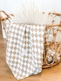 Soft, square baby blanket in a neutral sand-colored diamond pattern, made of high-quality muslin material.