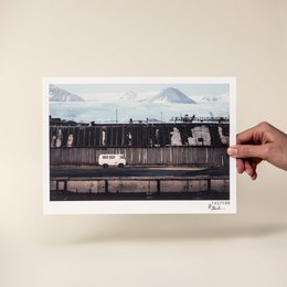 "Limited Art Print: Ghost Town at the End of the World - Hannes Becker. Poster featuring a desolate, abandoned train car in a snowy, mountainous landscape."
The image depicts an abandoned train car in a snowy, mountainous landscape. The train car appears to be made of weathered, wooden panels. The background features snow-capped mountains in the distance. This limited art print captures a sense of isolation and desolation in a remote, ghost town-like setting.
