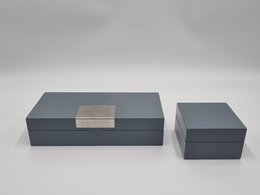 A set of two gray, high-gloss jewelry/storage boxes with a noble design. The larger box has a metal plate on the lid.