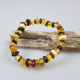 Amber gemstone bracelet for kids, featuring a colorful assortment of amber stones in various shapes and shades of yellow, orange, and brown.