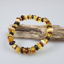 Amber gemstone bracelet for kids, featuring a colorful assortment of amber stones in various shapes and shades of yellow, orange, and brown.