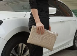  A gold or silver snakeskin-textured clutch bag with a rectangular shape and a structured design.