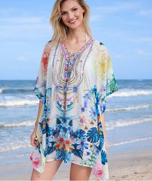 Colorful floral kaftan beach cover-up, lightweight flowing fabric, rainbow botanical print, short sleeves, boho style.