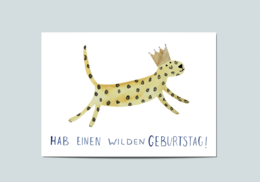 A colorful, spotted cat-like creature leaping across the image. The text "Hae einen wilden Geburtstag!" is written below, indicating this is a birthday card.
