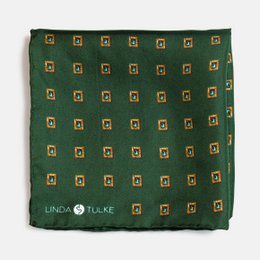 A green pocket square with a repeating pattern of yellow and white geometric shapes.