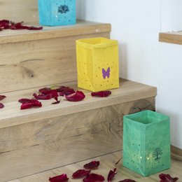 Colorful tea light holders with butterfly and paw print designs. Made of glass in various vibrant shades.