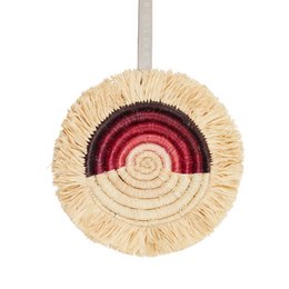 Decorative woven wall hanging with a colorful spiral design in shades of red and beige. Made of natural materials, this ornament has a rustic, boho-inspired aesthetic.