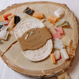 Oval-shaped soap dish made of natural loofah material, providing a textured surface for soap placement and drainage.