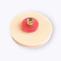 A round, red protest pin with a breast symbol on a white background.