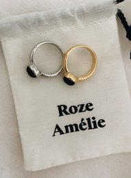 A statement ring featuring a sleek, minimalist design with a silver and gold tone finish. The ring has a simple, elegant style that can be worn for any occasion.