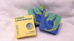 Nordlys soap bars in various colors and shapes, including round and rectangular bars. The bars appear to be made of natural materials and have a simple, minimalist design.