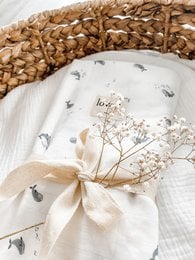 Soft, organic muslin baby blanket with delicate floral print and bow detail. Measures 120x120cm.