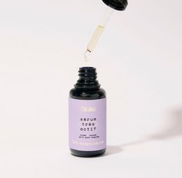 Anti-blemish serum with organic ingredients, suitable for face. Lavender-colored bottle with dropper applicator.