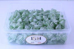 Anise-flavored hard candies from Carpentras, France, in a 1kg container. The candies have a distinctive green color and hexagonal shape.